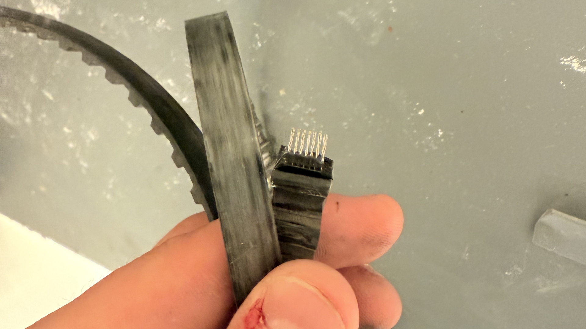 Broken sliding door motor belt removed during a professional sliding door service to restore smooth automatic door operation.