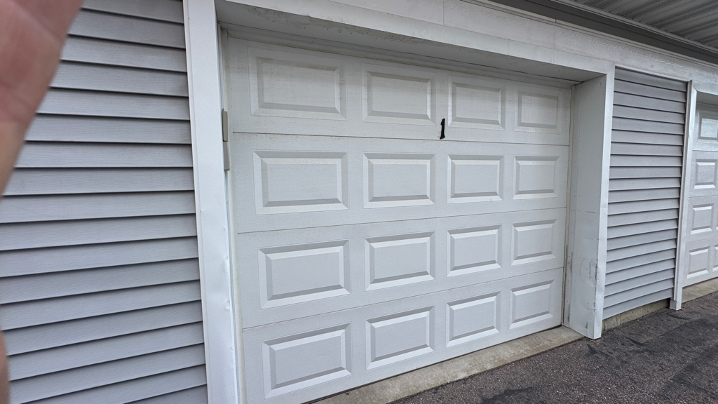 xterior view of a closed white sectional garage door at a residential property during garage opener troubleshooting in Middleton, WI.